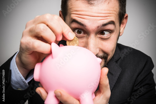Εκτύπωση καμβά Businessman putting money in his piggy bank
