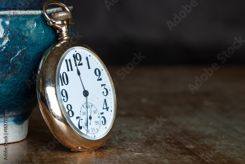 Vintage Golden Pocket Watch Resting on a Wooden Table
