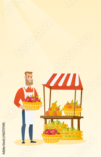 Greengrocer holding box full of apples.
