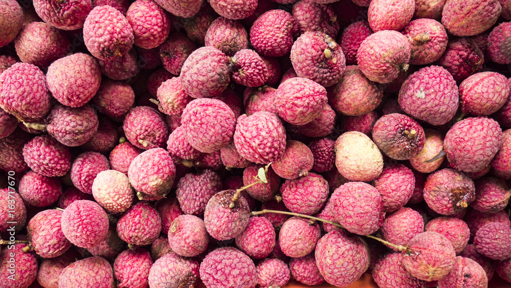 Lychee, Fresh lychee and peeled showing the red skin and white flesh with green leaf . Lychee, Fresh lychee and peeled showing the red skin and white flesh with green leaf .