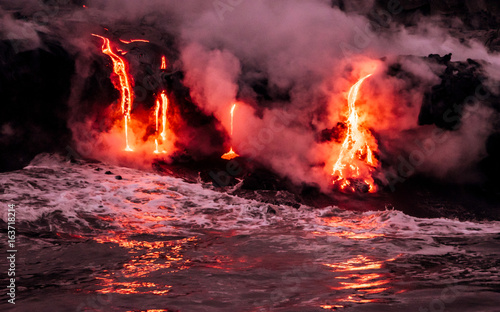 Fotografie Lava is flowing from volcano Kīlauea to Pacific ocean at night