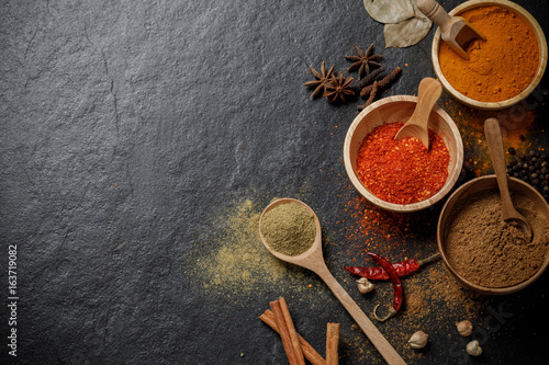 Herbs and spices over black stone background. Top view with copy space