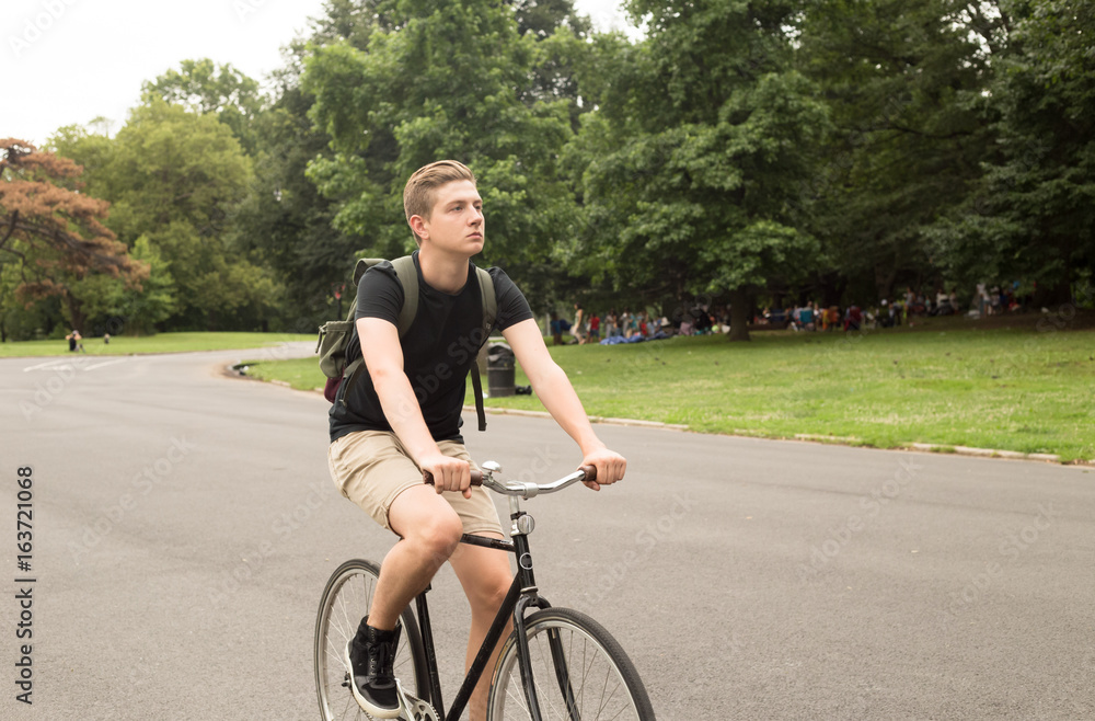 Modern young  college student ride bike in the park