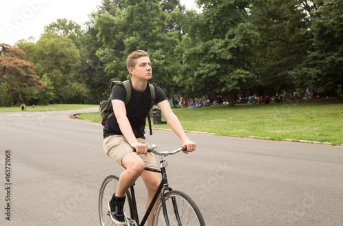 Modern young college student ride bike in the park