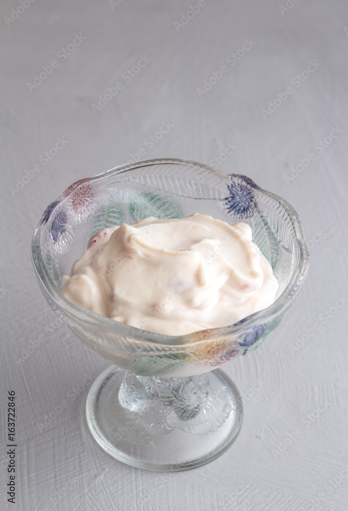 Natural strawberry yoghurt in glass bowl on grey background Natural strawberry yoghurt in glass bowl on grey background