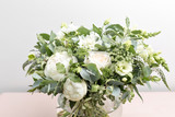 luxury wedding bridal bouquet with white peonies and mixed flowers on pink dresser