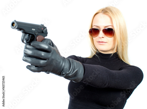 Young blonde woman in a black suit with a gun