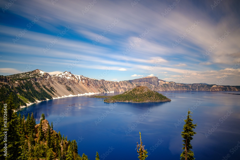Long exposure of a blue lake with an island from a viewpoint