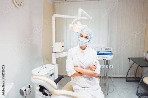 Young woman posing doctor in a dentist s office