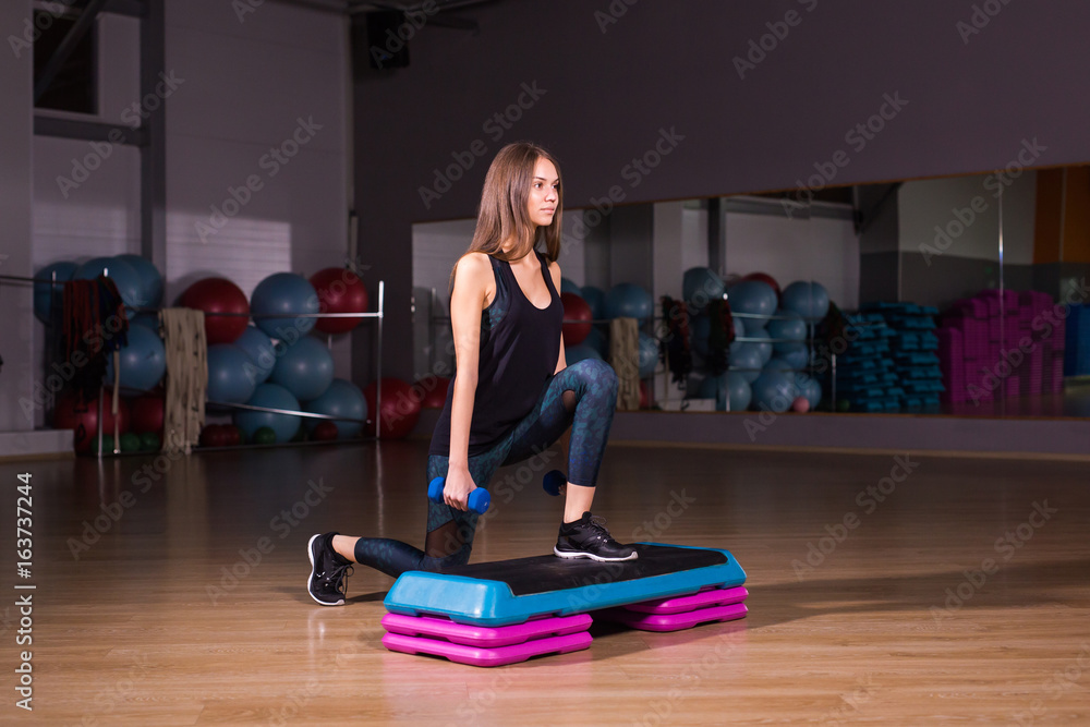 Sporty woman using step platform