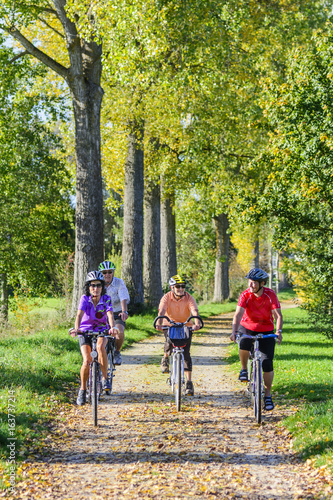 vier Senioren machen eine entspannte Radtour im Herbst