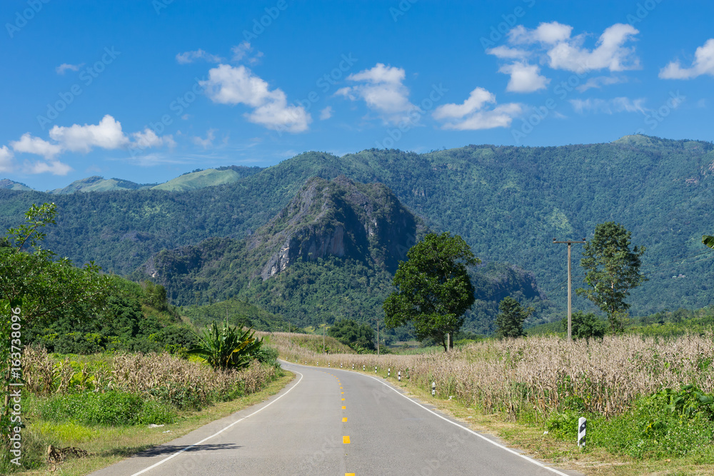 Fototapeta premium Street and mountain scenery with blue sky background