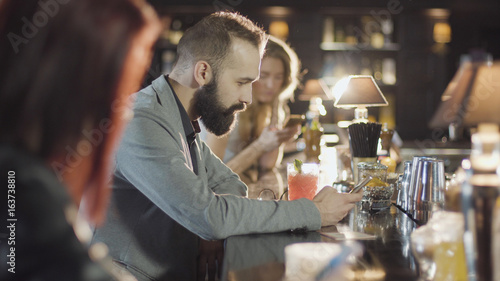 20s bearded guy people is drink cocktail sitting bar counter with menu