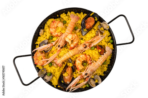 Spanish seafood paella in paellera on white background