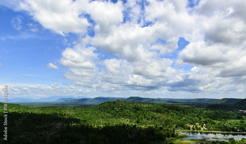 Blue sky with white clouds. Top view from mountain see the forest below and Cloudy sky background.