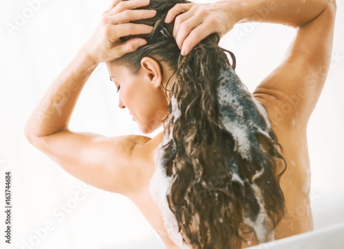 Young woman washing hair. rear view