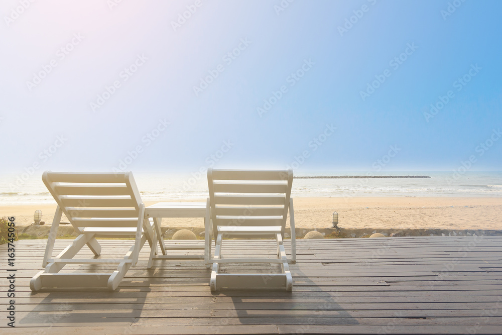 Bench on the beach at yellow sunset