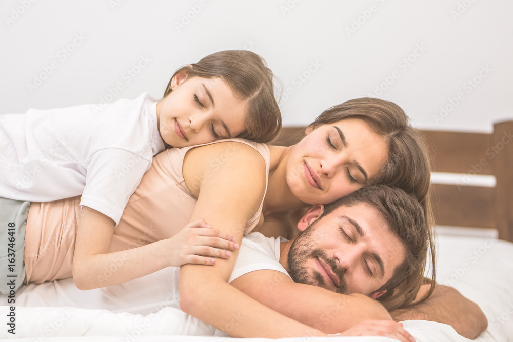 The happy family sleeping on the comfortable bed The happy family sleeping on the comfortable bed