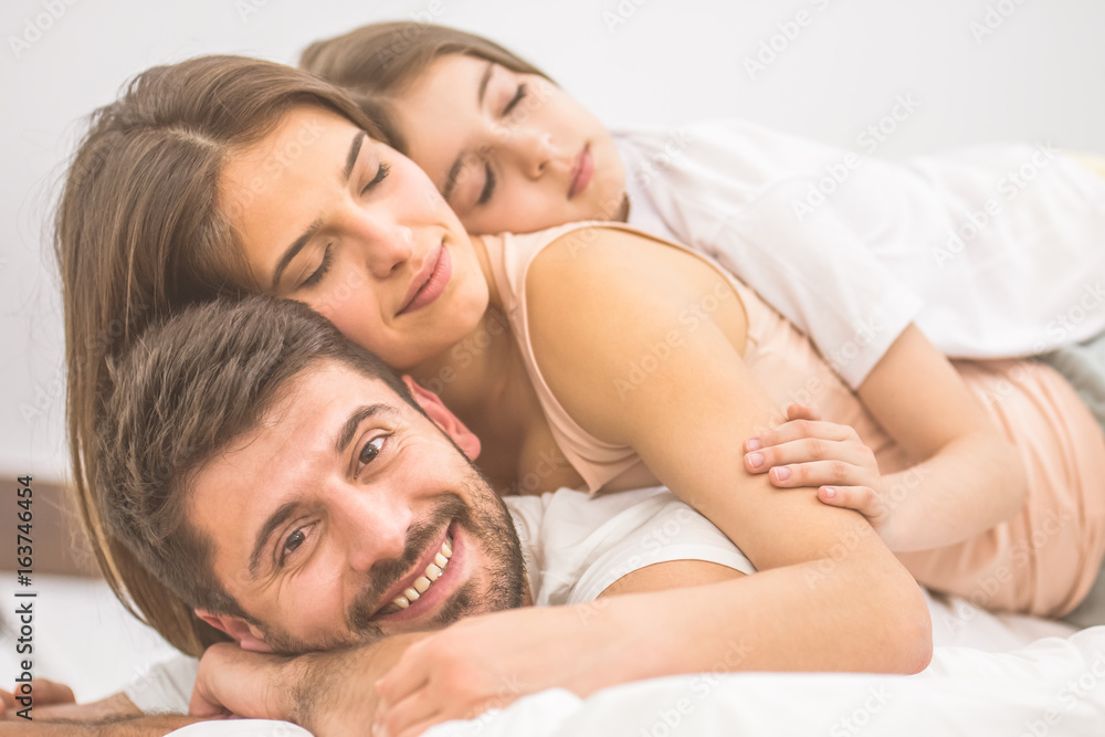 The man lay with sleeping family on the bed The man lay with sleeping family on the bed