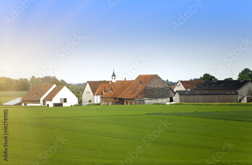 rural areas in Germany, Bavaria, with brightly green fields and trees small and.village .