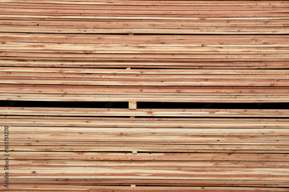 Pattern of stacked wooden plank boards at sawmill lumberyard Pattern of stacked wooden plank boards at sawmill lumberyard