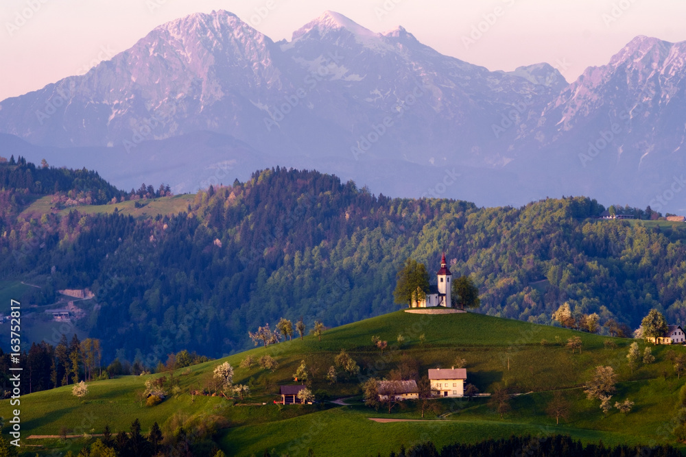 Obraz premium Church of St Thomas at Praprotno, with Kamnik Savinja alps in the background