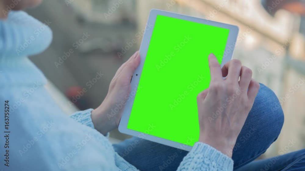 Young Woman in blue sweater sitting near window uses Tablet PC with pre-keyed green screen. Few types of gestures - scrolling up and down, tapping, zoom in and out. Perfect for screen compositing Young Woman in blue sweater sitting near window uses Tablet PC with pre-keyed green screen. Few types of gestures - scrolling up and down, tapping, zoom in and out. Perfect for screen compositing