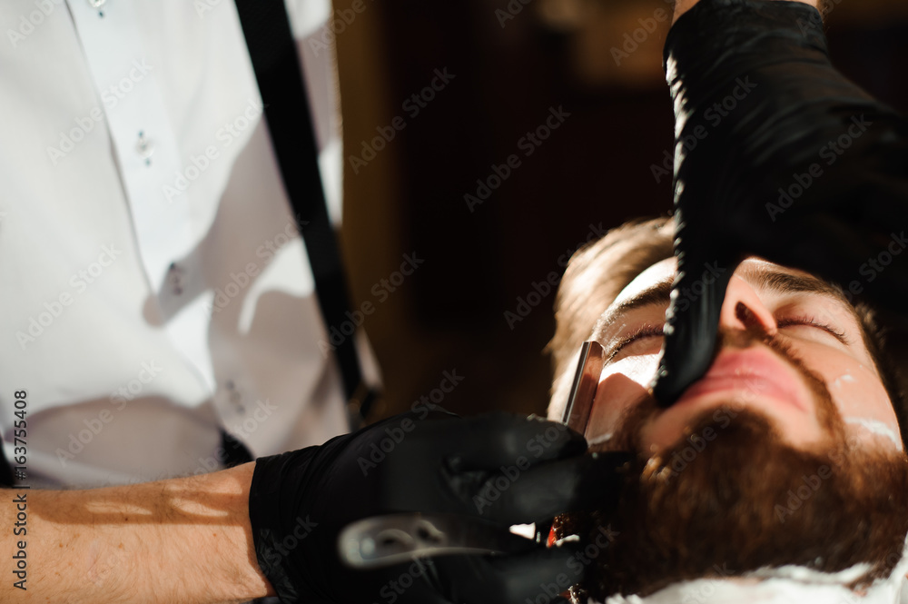 Master cuts hair and beard of men in the barbershop Master cuts hair and beard of men in the barbershop