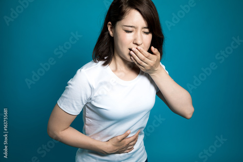 Young woman having a stomachache and being going to vomit.