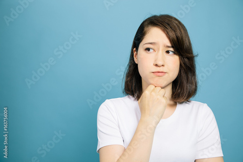 woman thinking on blue background.