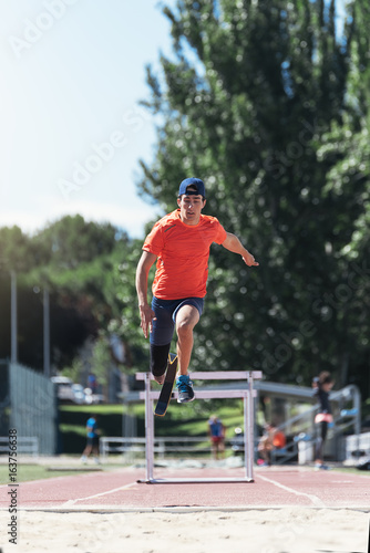 Disabled man athlete jumping with leg prosthesis.