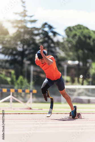 Disabled man athlete training with leg prosthesis. photo