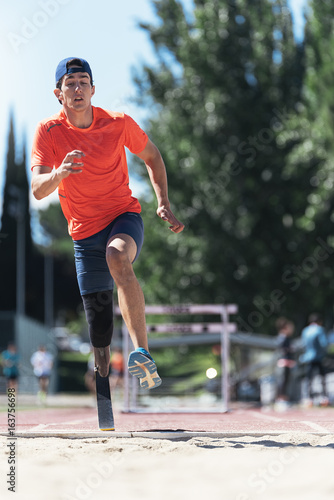 Disabled man athlete jumping with leg prosthesis.