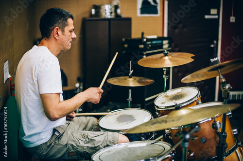 Behind scene. Drummer artist musician playing the drums with drumsticks photo