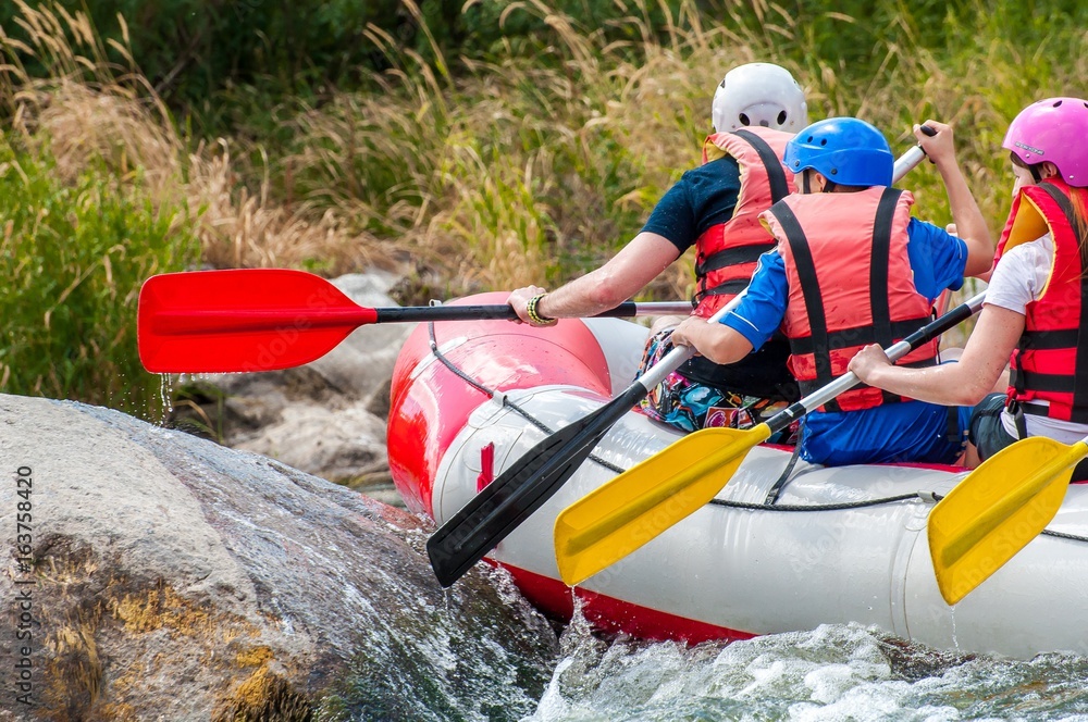 Naklejka premium Rafting. Close-up view of oars with splashing water.