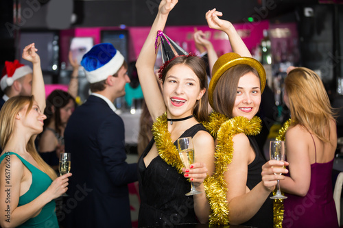 Cheerful females and males celebrating new year