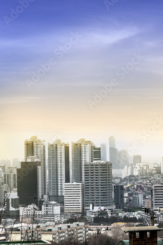 Seoul cityscapes yellow and orange sunset lighting effect, skyline, high rise office buildings and skyscrapers in Seoul city, winter daylight, top view in winter, Seoul,Korea, in mist winter season © lukyeee_nuttawut