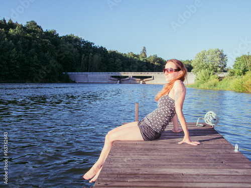 young woman at jetty in summer