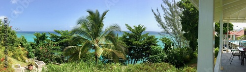 Luxurious tropical resort (hotel) with blue sky, white patio, lush green palm trees & blue ocean in Boscobell near Oracabessa (James Bond beach) on the Caribbean island of Jamaica in the West Indies 