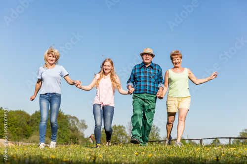 Happy family running on the field. Generations
