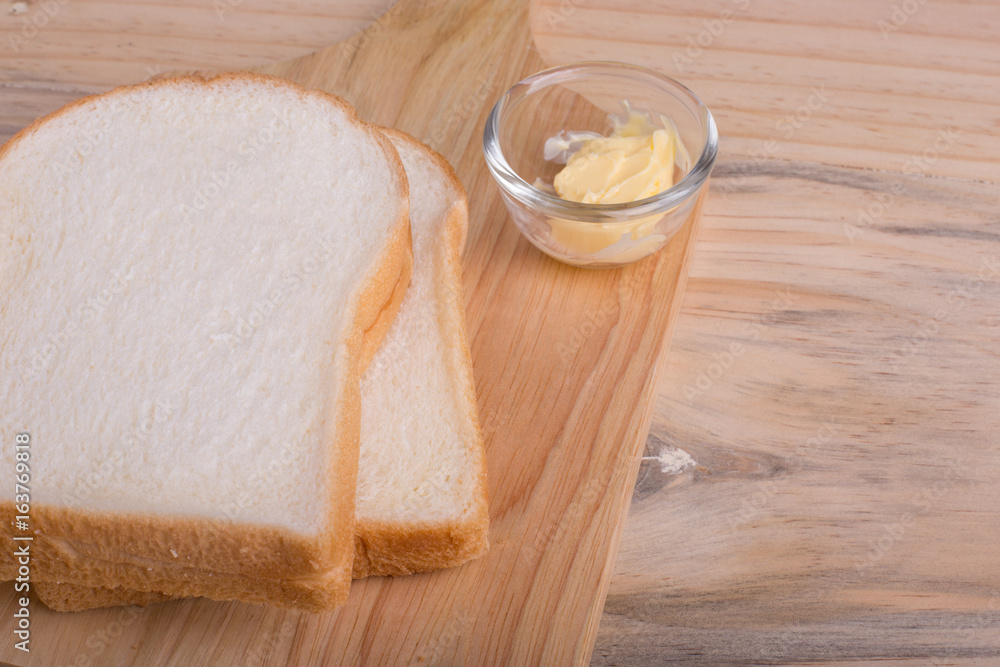 Slices bread with butter on wooden table Slices bread with butter on wooden table