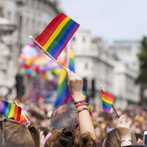 Woman's hand waving rainbow flag during pride march photo