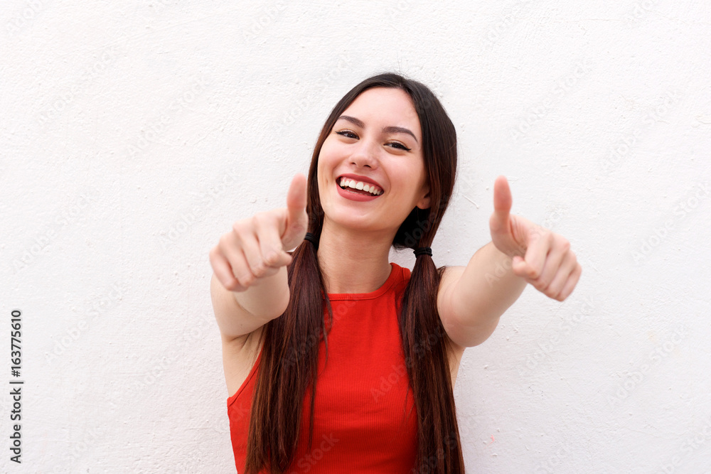 Close up positive young woman smiling with thumbs up Close up positive young woman smiling with thumbs up