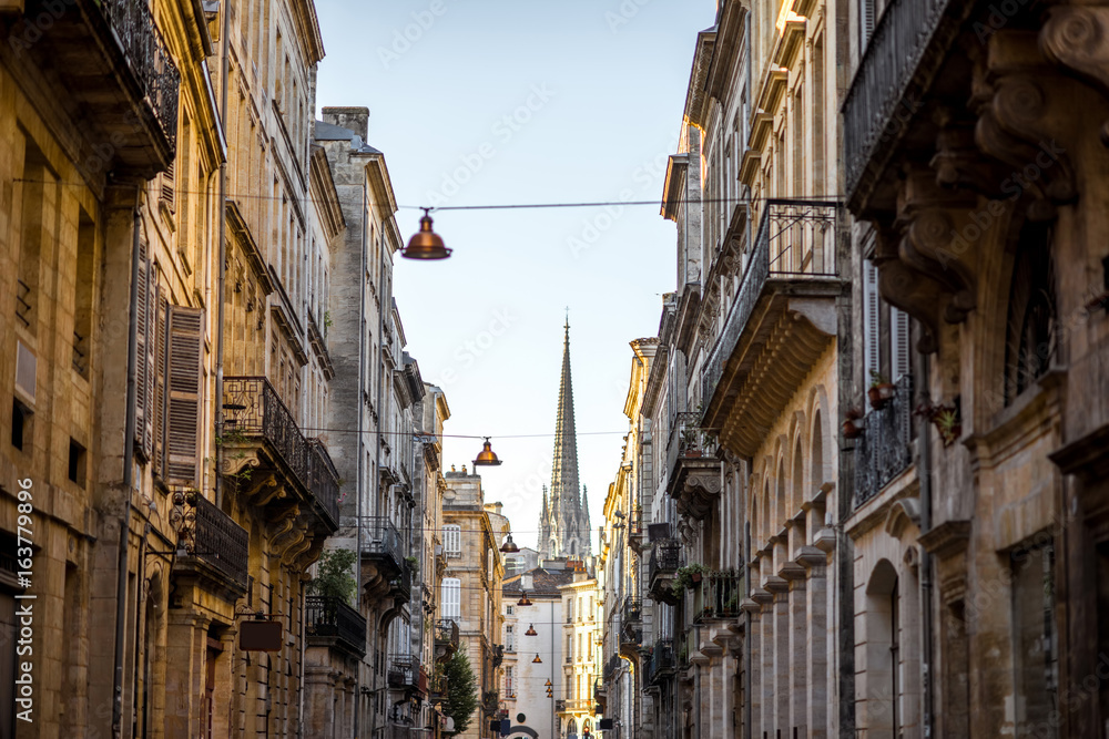 Beautiful morning street view with old buildings and tower of saint Michel cathedral in Bordeaux city, France