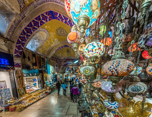 Unidentified Tourists visiting and shopping in the Grand Bazaar in Istanbul.traditional handmade decorative mosaic multi-colored Turkish lamps for sale hanging on the front side. © epic_images