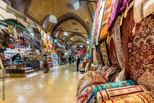 ISTANBUL, TURKEY- APRIL 17, 2017: Unidentified Tourists visiting and shopping in the Grand Bazaar in Istanbul.Interior of the Grand Bazaar with Turkish  rug and carpet on the front side.