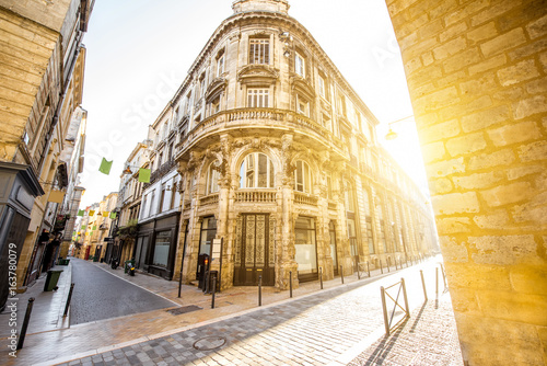 Street view with beautiful buildings during the sunrise in Bordeaux city, France