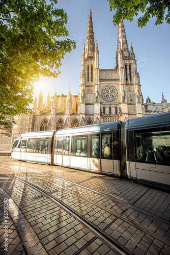 Morning view on the beautiful saint Pierre cathedral with modern tram in Bordeaux city, France