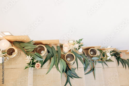  White and gold candles with flowers and decor are arranged on the steps