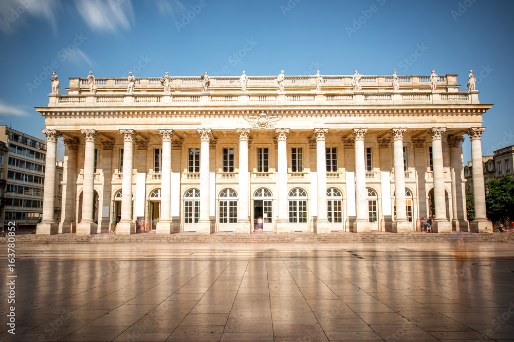 View on the facade of Grand Theatre building in Bordeaux city, France. Long exposure image technic with motion blurred people and clouds